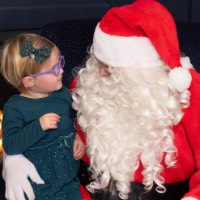 Little girl looks at Santa's face